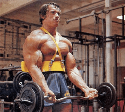 Arnold Schwarzenegger fazendo o movimento de rosca inversa na barra W