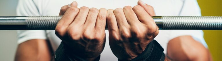 homem fazendo treino de antebraço com duas mãos na barra