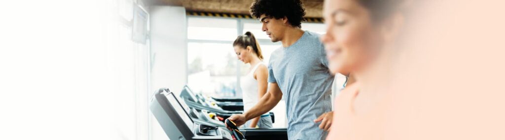 homem na esteira olhando para o monitor pensando se deve fazer cardio antes ou depois da musculação