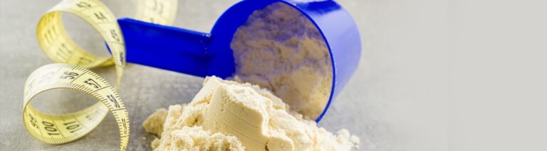 Foto em close de um medidor derramando whey sobre uma superfície - como preparar Whey Protein?