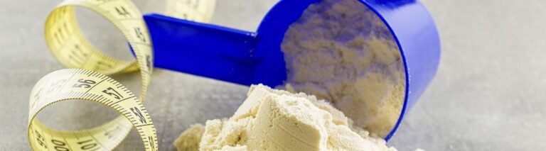 fita metrica e suplemento em cima da mesa representando como ganhar massa muscular