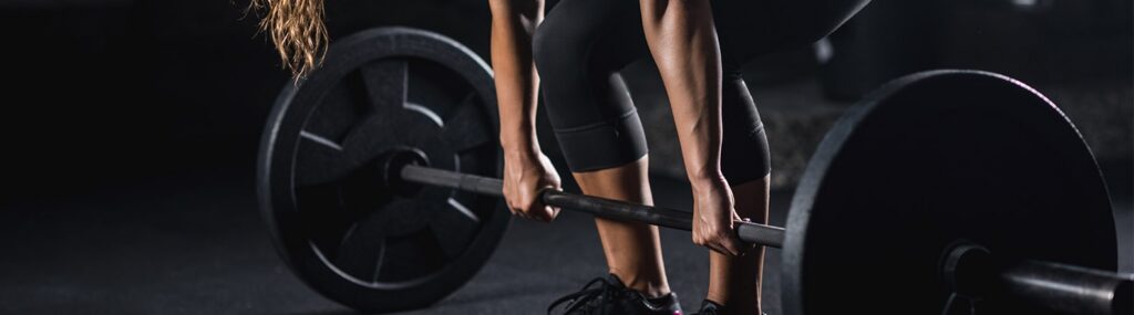 modelo segurando barra representando o melhor pack para musculação