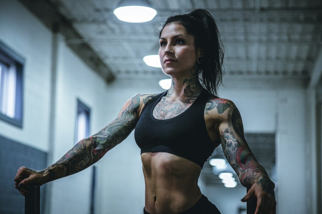 Mulher realizando exercício de força em academia, prática que contribui para acelerar o metabolismo, aumentar o gasto calórico e melhorar a performance física.