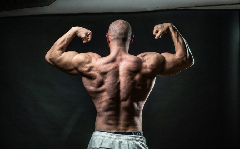 Homem exibindo desenvolvimento dos músculos das costas, resultado do fortalecimento dorsal com exercícios como a remada baixa no treino de musculação.