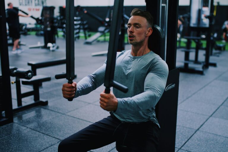 Homem realizando crucifixo na máquina durante treino de peito, exercício isolado que promove maior ativação do peitoral e contribui para hipertrofia muscular.