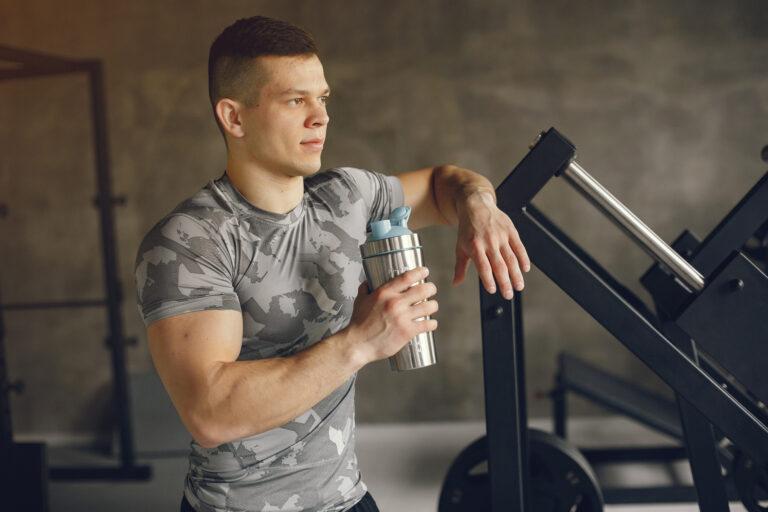 Homem na academia segurando shake de whey zero lactose, indicado para quem procura uma fonte de proteína sem desconforto digestivo.