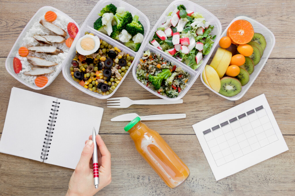 Alimentos saudáveis e um planner sobre a mesa para quem vai começar a reeducação alimentar.