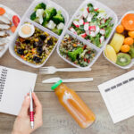 Alimentos saudáveis e um planner sobre a mesa para quem vai começar a reeducação alimentar.